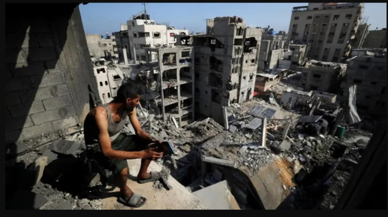 গাজার উত্তরাঞ্চলের আল-শাতি শরণার্থী শিবিরে ইসরায়েলি হামলায় ধ্বংসপ্রাপ্ত ভবনগুলো দেখছেন এক ফিলিস্তিনি ব্যক্তি